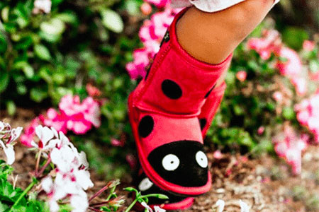 A pair of ladybug Emu boots for girls.