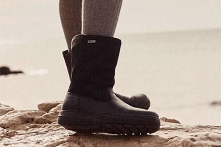 A child wearing a pair of black waterproof narrow boots.