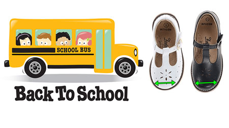 A pair of black and white wide t-strap school shoes for kids.