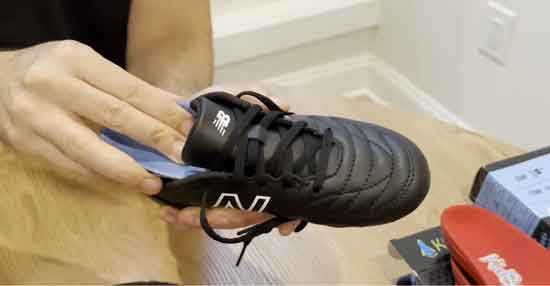 Fitting kids' sports insoles inside supportive soccer cleats