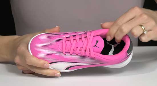 An image of a pair of pink indoor soccer shoes with extra cushion and padding to prevent blisters.